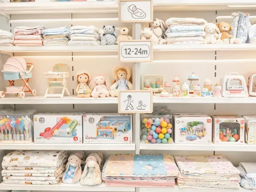 Retail shelf with baby toy category signs by age stage